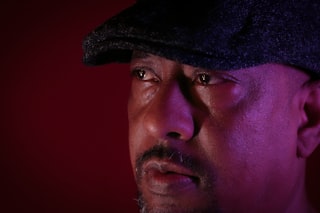Man wearing a flat cap with a red background